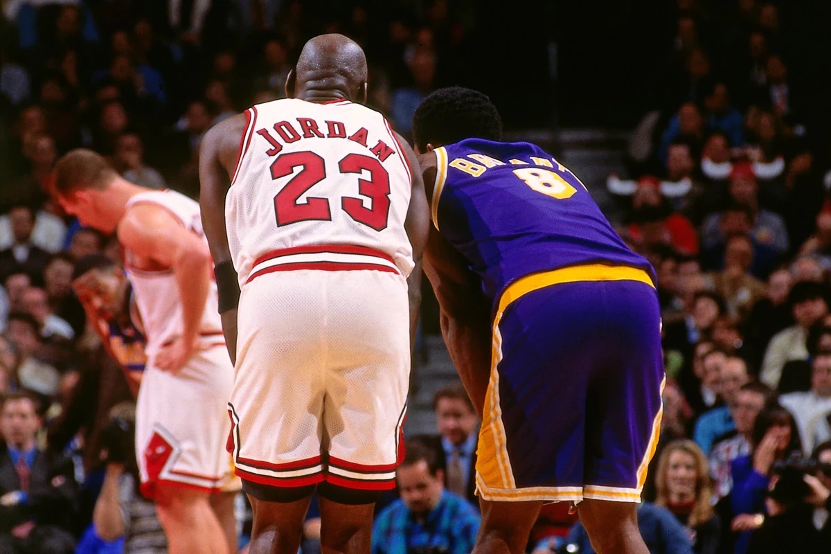 Kobe Bryant pauses for a moment with childhood idol Michael Jordan during a game on Dec. 19, 1997.